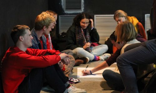 A group of participants sitting on the floor discussing